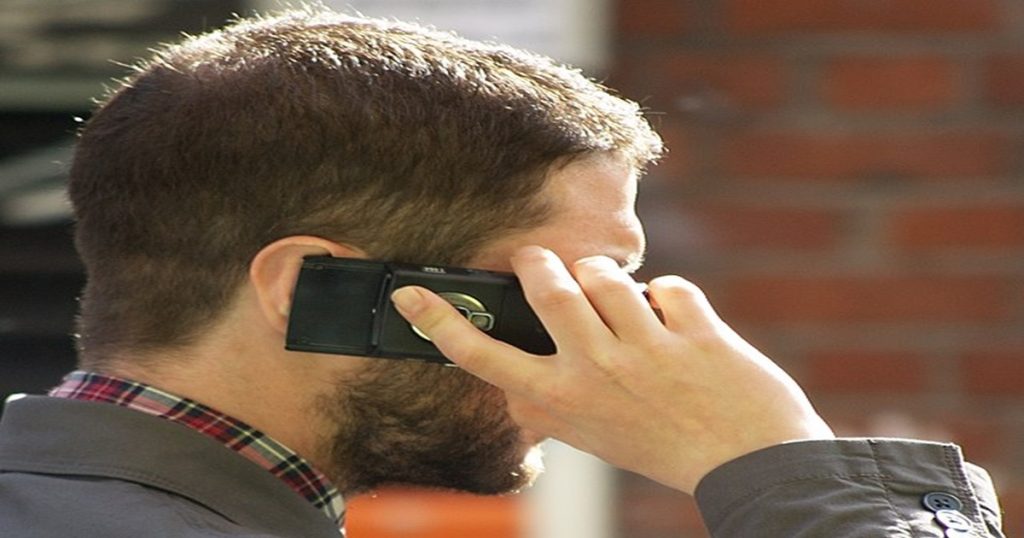 Muž s mobilním telefonem u ucha.